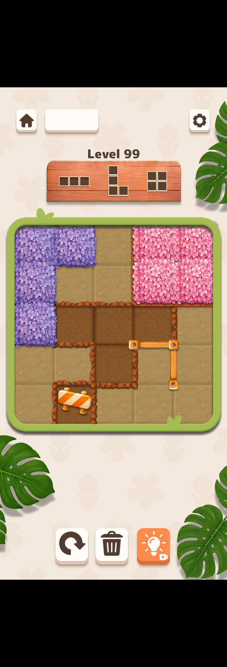 Flower Fit gameplay showing pink and purple flower blocks in a green garden puzzle board